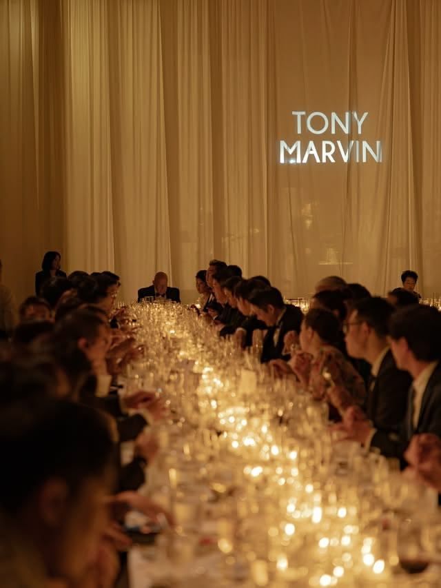 Guests seated at a long candlelit dinner table