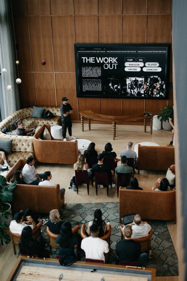 Wood-paneled room with a screen and seated audience